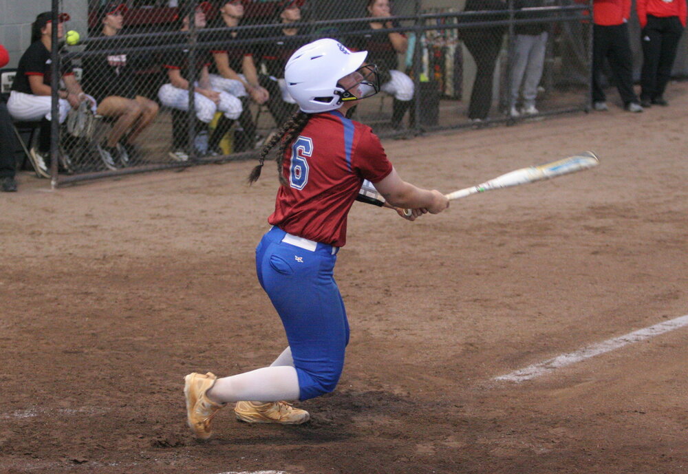 softball player hitting a ball during a game